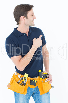 Man with tool belt around waist pointing against white backgroun