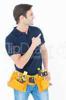 Man with tool belt around waist pointing against white backgroun