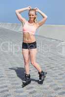 Fit blonde rollerblading on the promenade