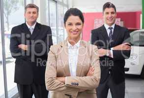 Smiling business team standing with arms crossed