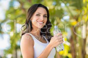 Pretty brunette drinking bottle of water