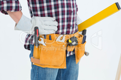 Repairman wearing tool belt while standing with hands on hips