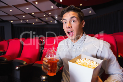 Surprised young man watching a film