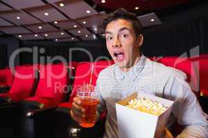 Surprised young man watching a film