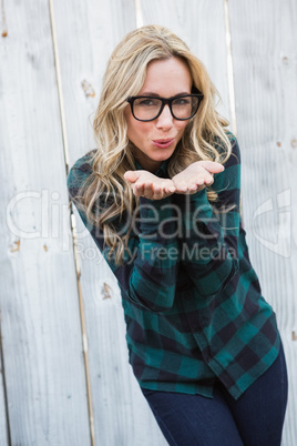 Pretty blonde in striped shirt blowing a kiss