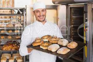 Happy baker showing tray of fresh bread