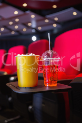 Empty rows of red seats with pop corn and drink on the floor