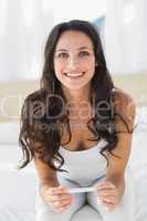 Excited brunette waiting on pregnancy test