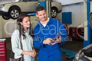 Mechanic showing tablet pc to customer