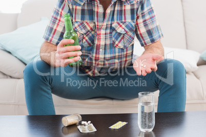 Man with a beer and his medicine laid