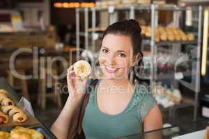 Pretty brunette showing a cupcake