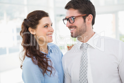 Smiling business colleagues looking each other