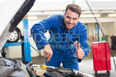 Mechanic examining under hood of car