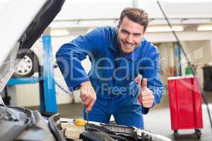 Mechanic examining under hood of car