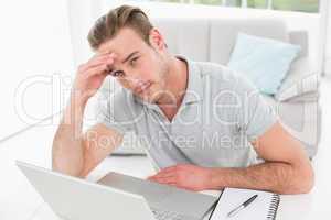 Anxious businessman using laptop and notebook