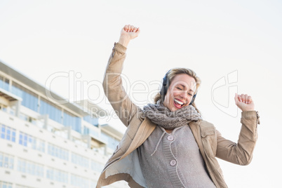 Happy blonde listening music with headphones