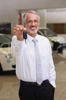 Salesman standing while offering car keys