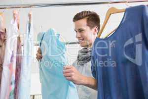 Smiling student holding a blue shirt