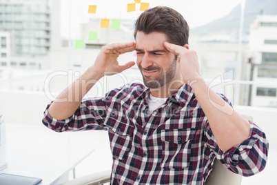 Businessman sitting with severe headache