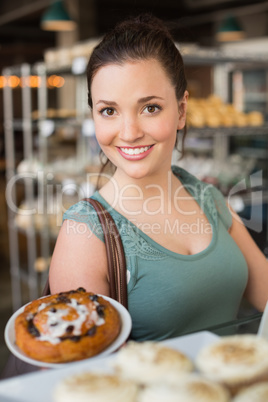 Pretty brunette showing a pastry