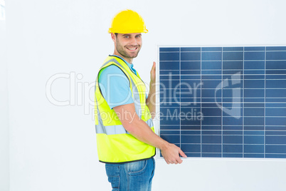 Portrait of happy architect holding solar panel