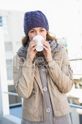 Pretty blonde in warm clothes drinking hot beverage