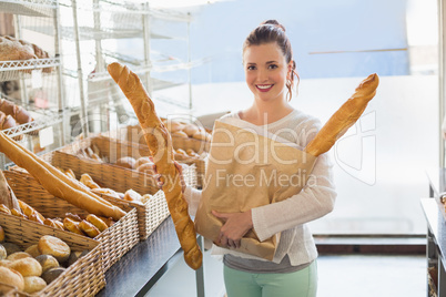 Pretty brunette holding bag of bread