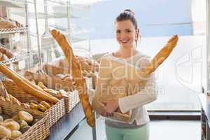 Pretty brunette holding bag of bread