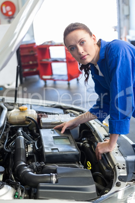 Mechanic examining under hood of car