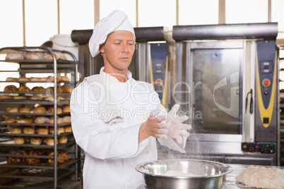 Baker clapping flour from his hands