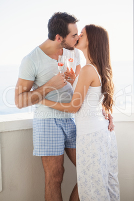 Cute couple kissing while toasting with champagne