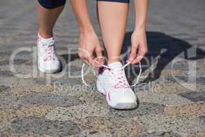 Woman tying her shoelace on running shoe