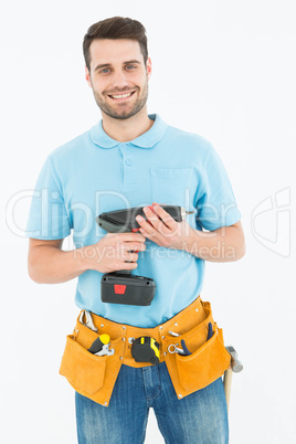 Happy repairman holding hand drill