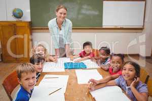 Teacher and pupils working at desk together