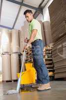 Focused man moping warehouse floor