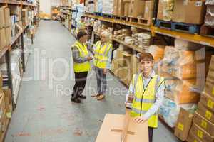 Warehouse worker sealing cardboard boxes for shipping