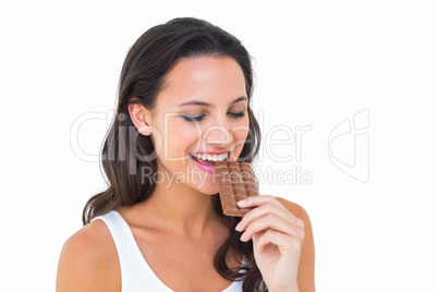 Pretty brunette eating bar of chocolate