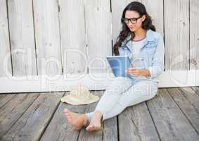 Pretty hipster sitting on ground with tablet