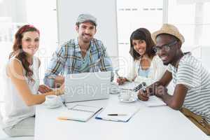 Smiling colleagues using laptop together