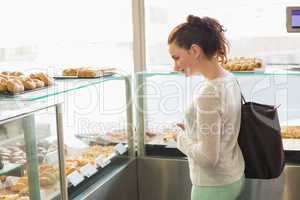 Pretty brunette picking out a pastry