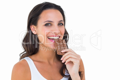 Pretty brunette eating bar of chocolate