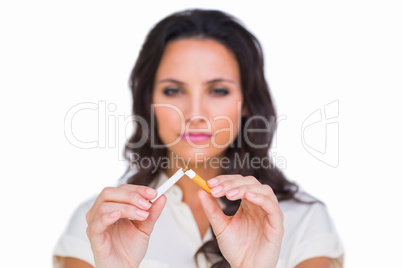 Pretty brunette breaking a cigarette