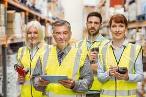 Smiling warehouse team looking at camera