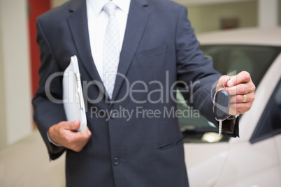 Close up of businessman holding car key and clipboard