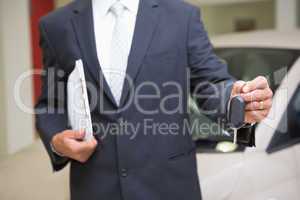 Close up of businessman holding car key and clipboard