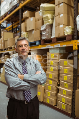 Smiling male manager with arms crossed