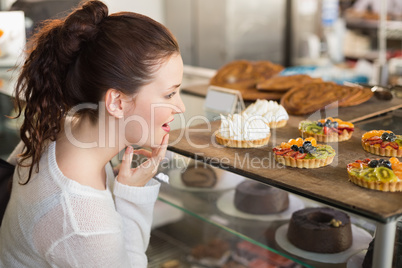 Pretty brunette looking at tarts