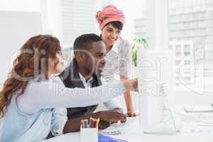 Coworkers pointing computer and interacting