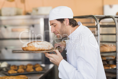 Smiling baker smelling fresh bread