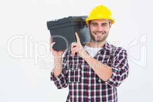 Happy male repairman carrying toolbox on shoulder